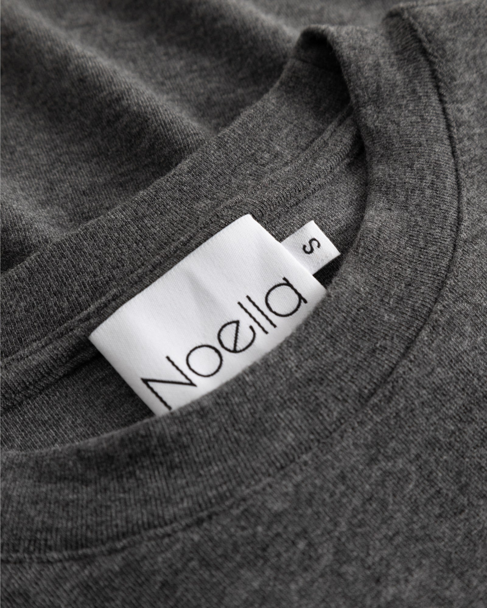 Noella Lidie LS Top i mørkegrå melange, blød langærmet top med rund hals, vist på model.