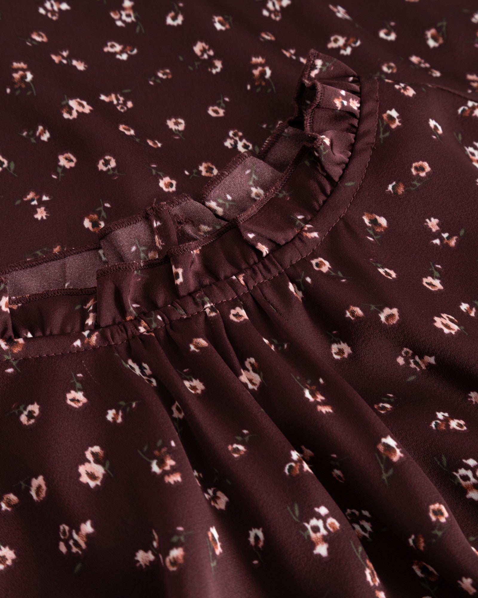 Noella N-Ruth kjole i burgundermønster, med blomstret design og elegant snit, vist på model.