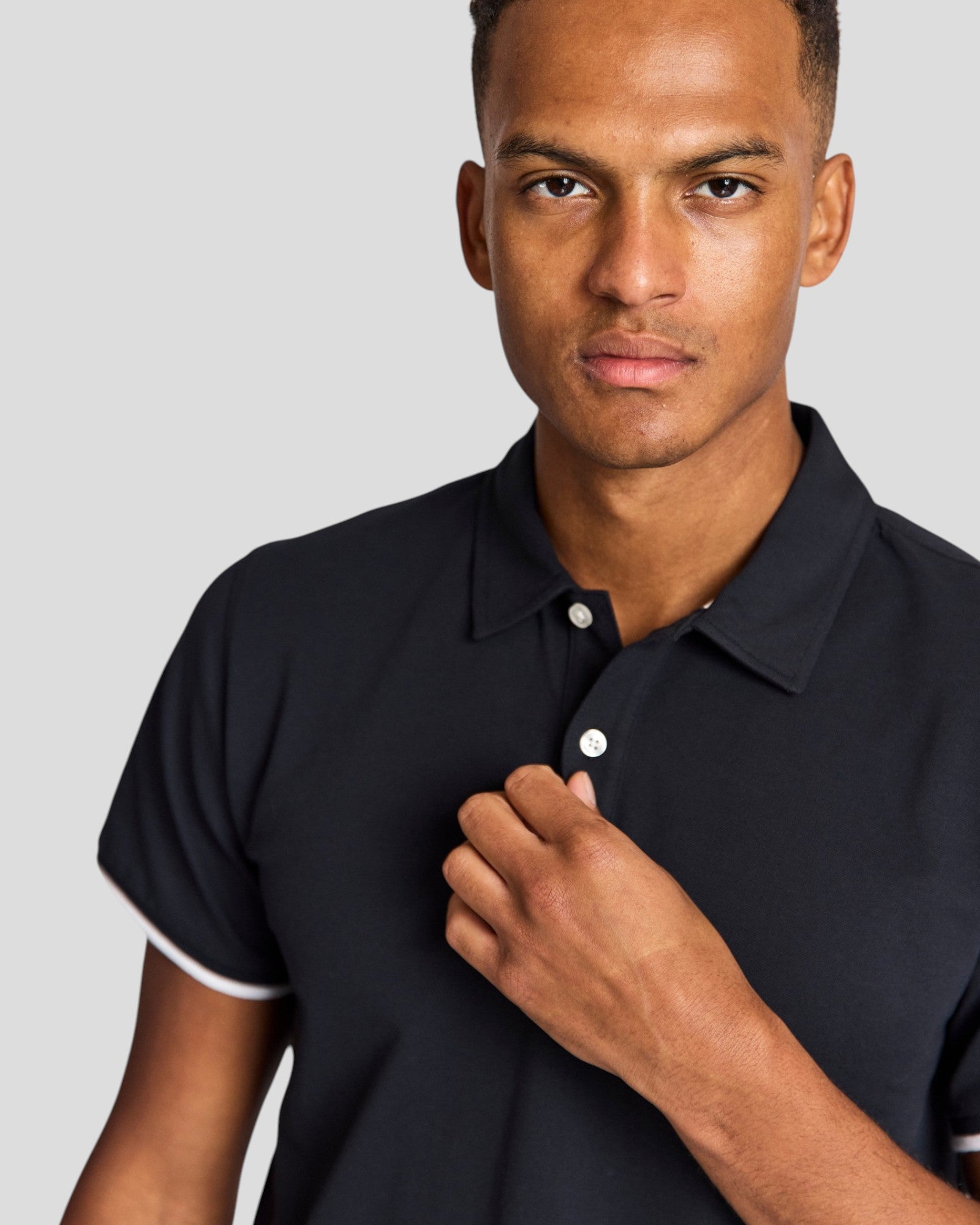 Navy Delos regular fit polo shirt by Bruun & Stengade displayed on a hanger, showcasing short sleeves and classic collar.