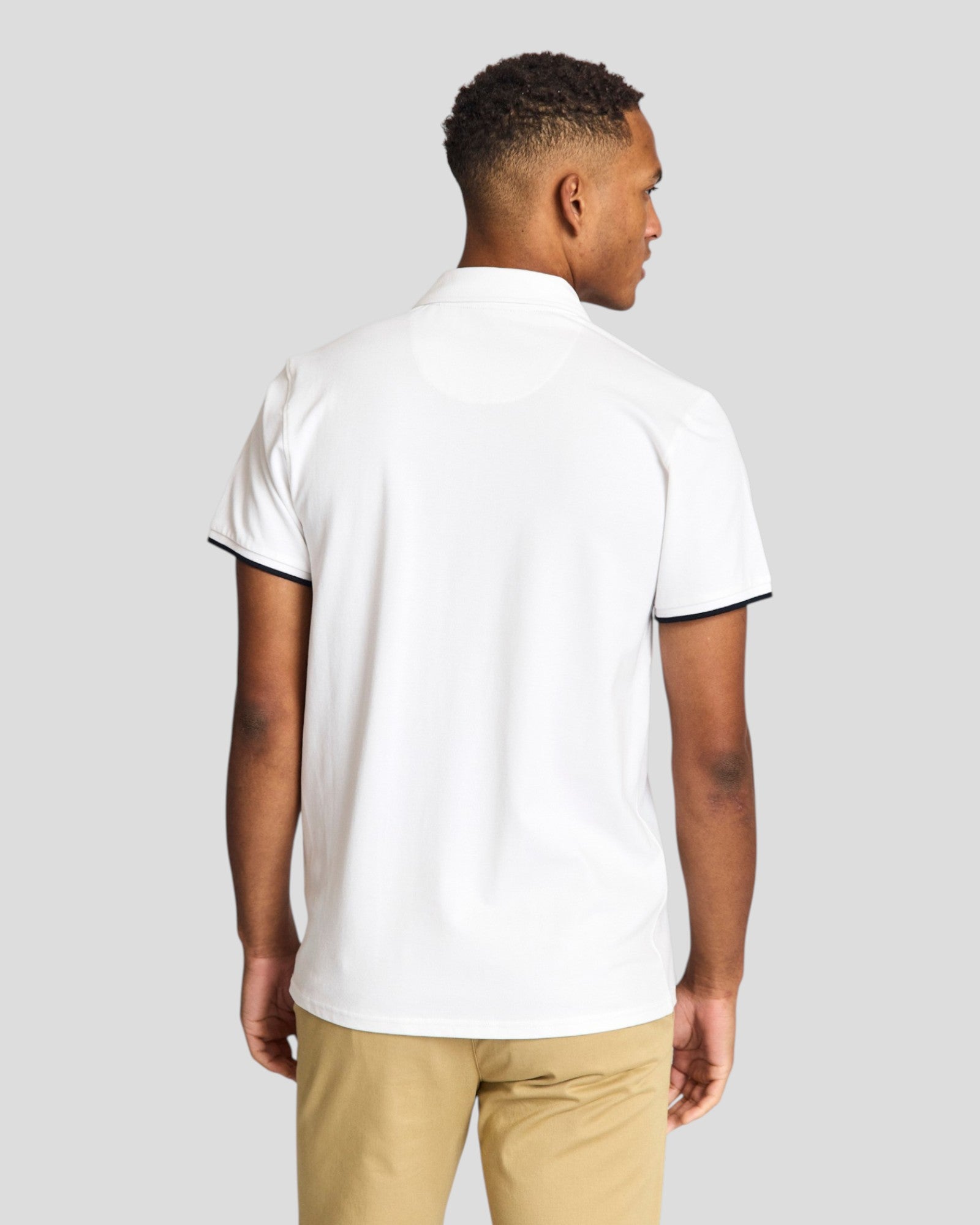 White Bruun & Stengade Delos regular fit polo shirt displayed on a hanger with a classic collar and short sleeves.