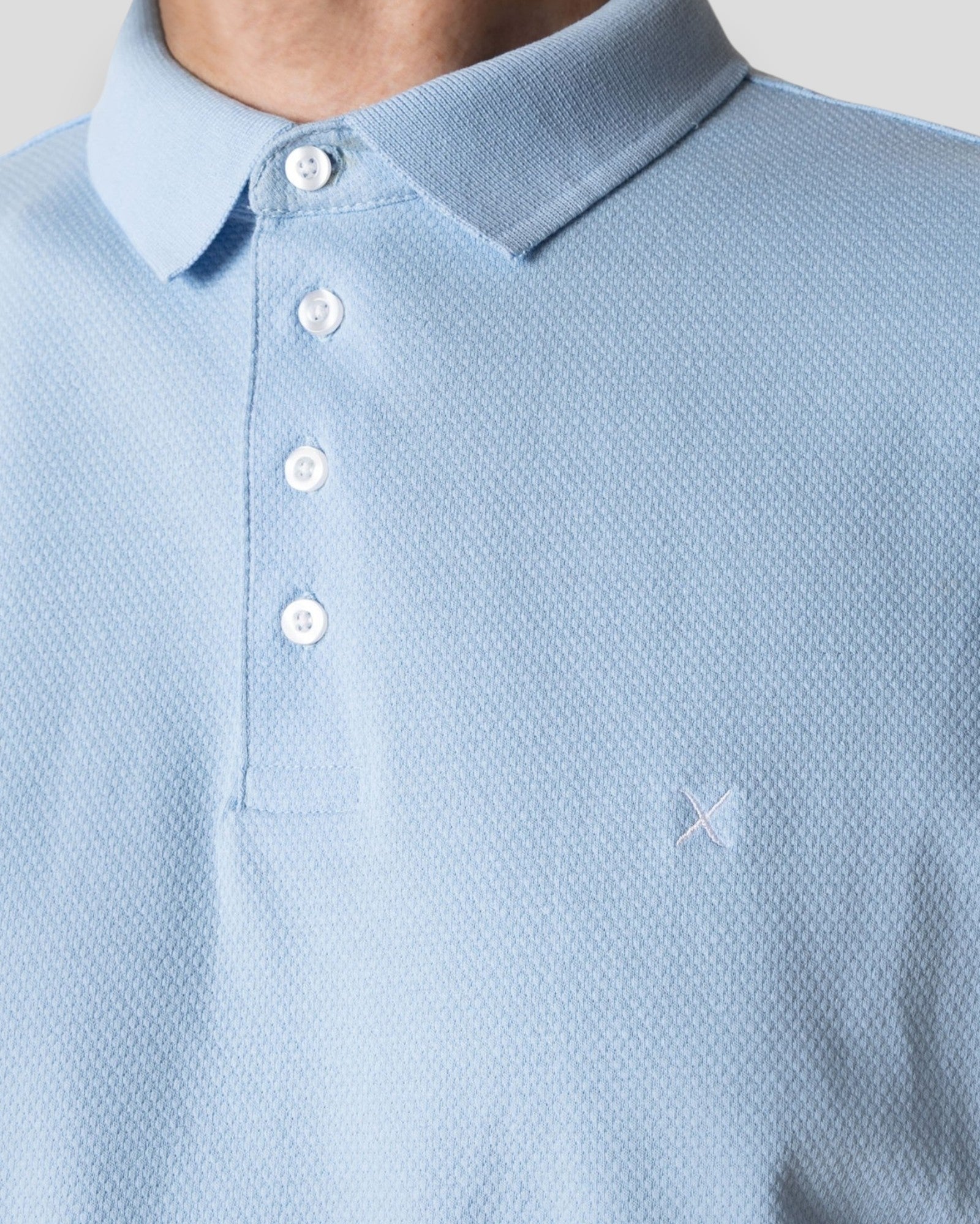 Light blue Silkeborg Stretch Polo by Clean Cut Copenhagen, showcasing a fitted polo shirt with a classic collar and short sleeves.