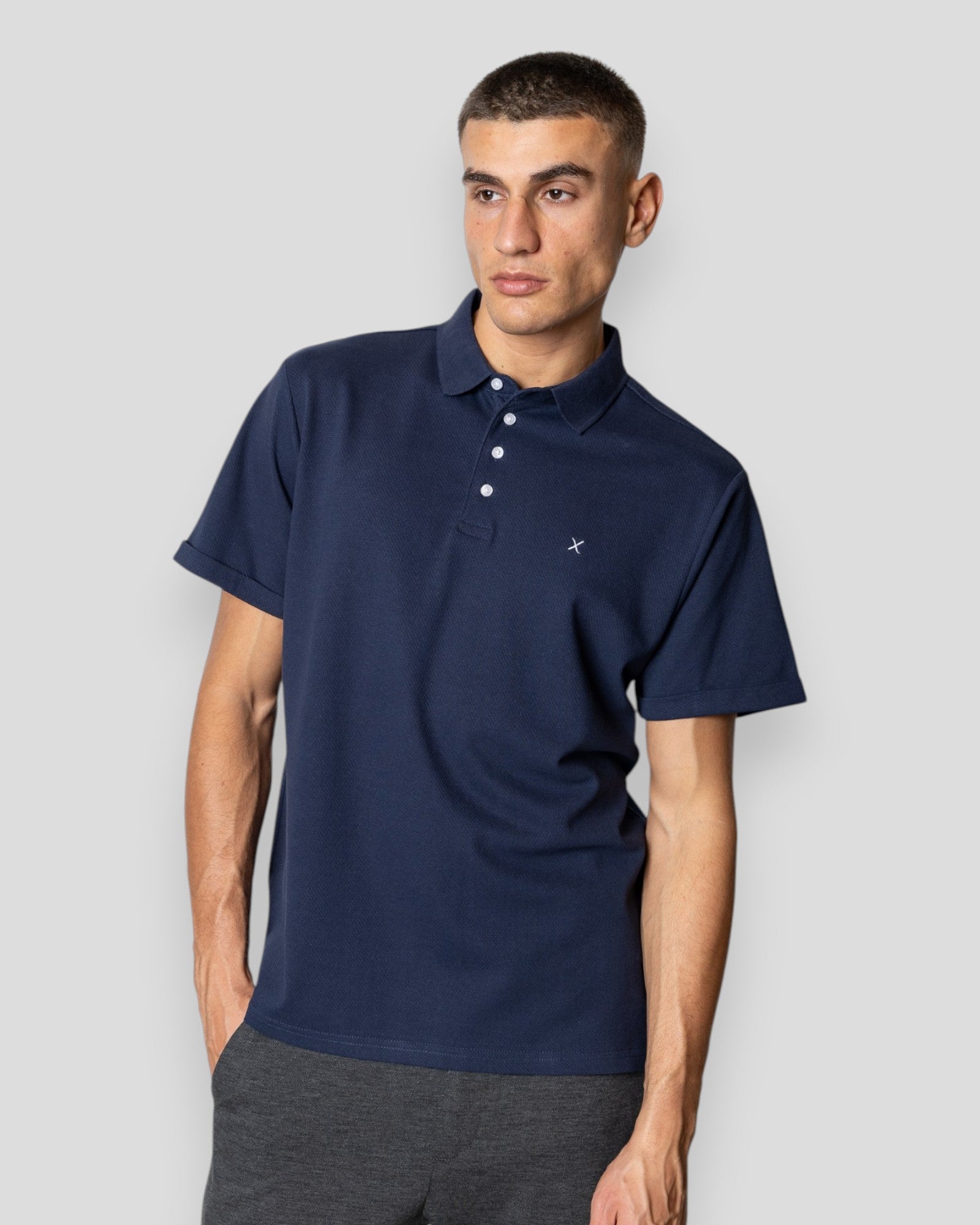 Navy Silkeborg Stretch Polo shirt by Clean Cut Copenhagen displayed on a hanger with a close-up of fabric texture.
