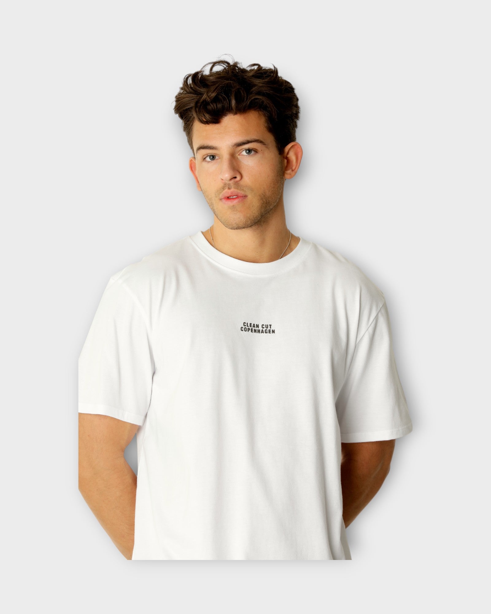 Cohen Organic Tee White fra Clean Cut Copenhagen. Hvid T-shirt til mænd med logo. Her ses closeup af logo.