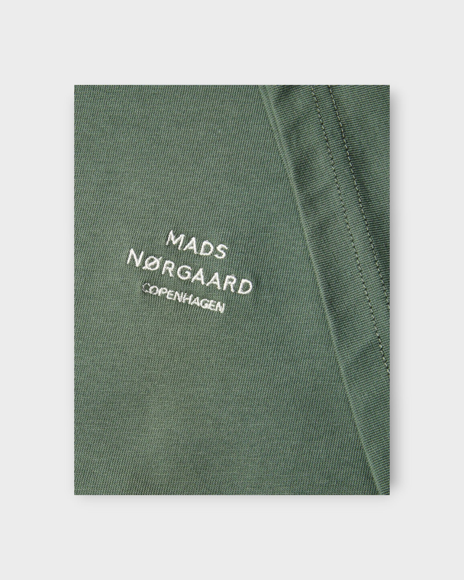 Frode Emb Logo Tee Duck Green - Grøn Mads Nørgaard T-shirt til Mænd. Her ses logoet i closeup.