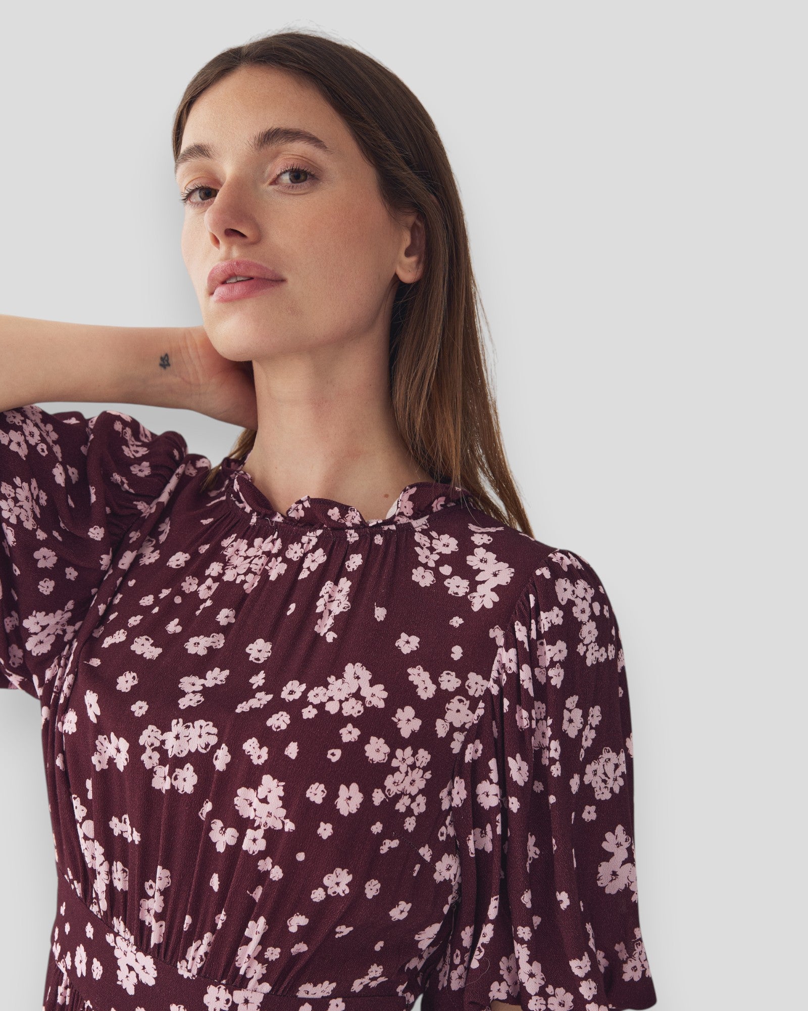 Rød og burgunder N-Ruth kjole fra Noella med print, vist på model, perfekt til festlige lejligheder.