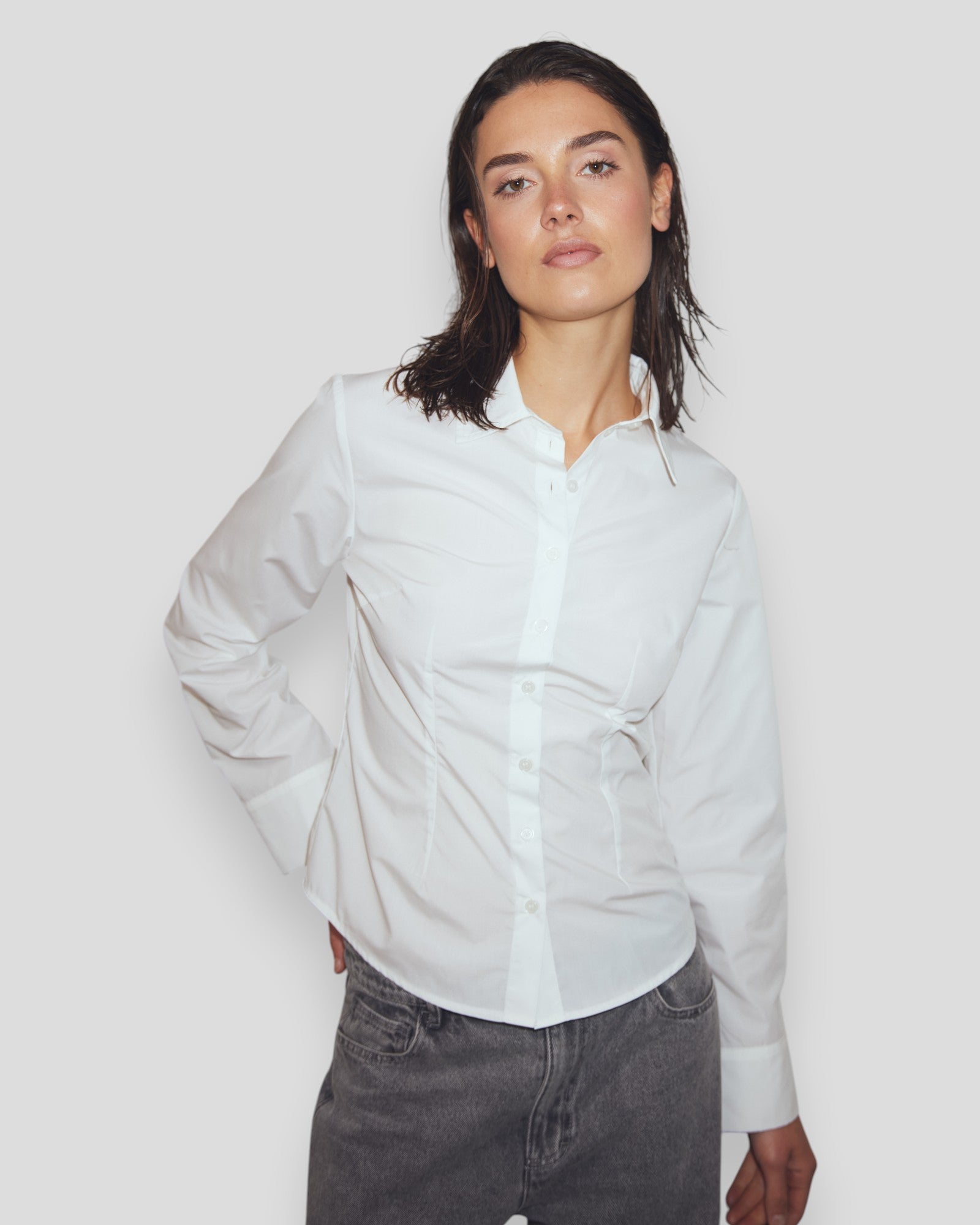 Hvid N-Loyce dameskjorte fra Noella, vises på model med let foldet ærme og klassisk snit, perfekt til hverdag.
