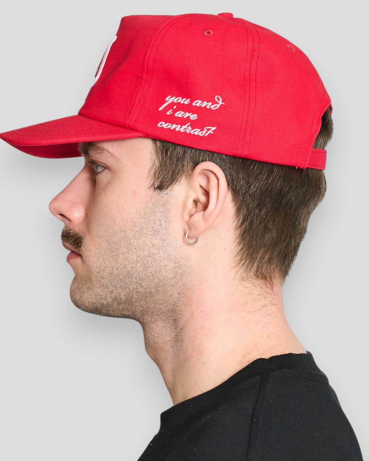 Rød baseballkasket i needlepunch-stil fra Lau Lau, afslappet hovedbeklædning med justerbart bånd og sporty design.