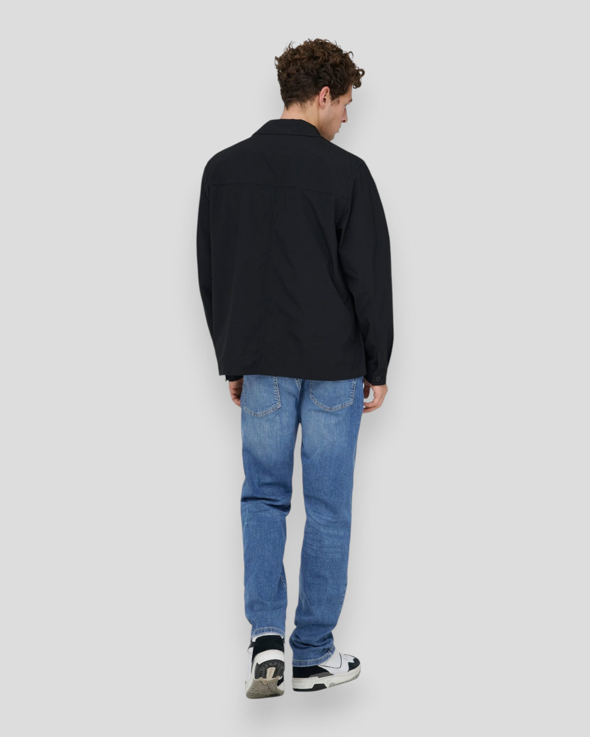 Mellemblå denim jeans fra ONLY & SONS med vævede detaljer, vist på en model i et efterår og vinter-look.