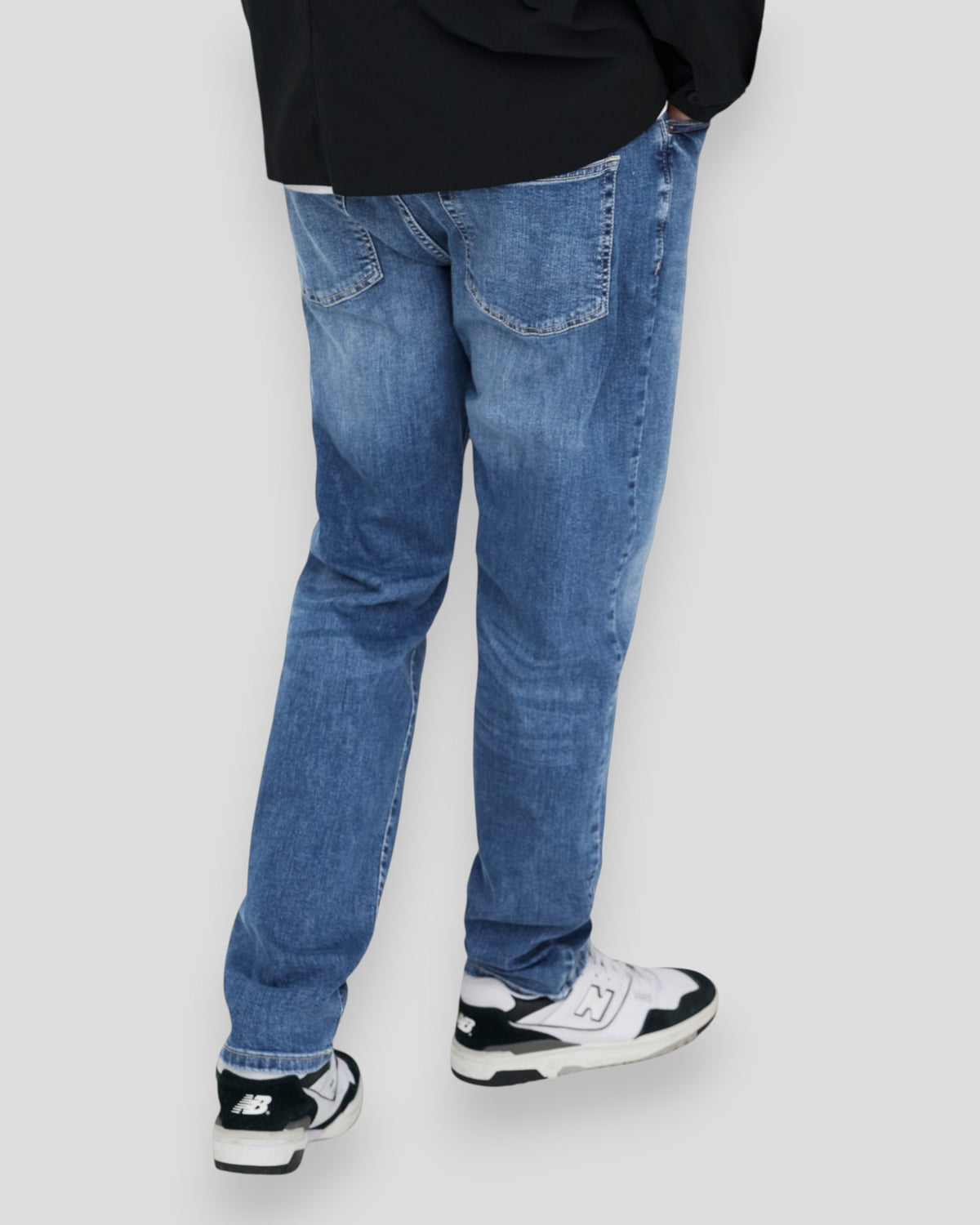 Mellemblå denim jeans fra ONLY & SONS med weft-regulation, vist på model foran en neutral baggrund.