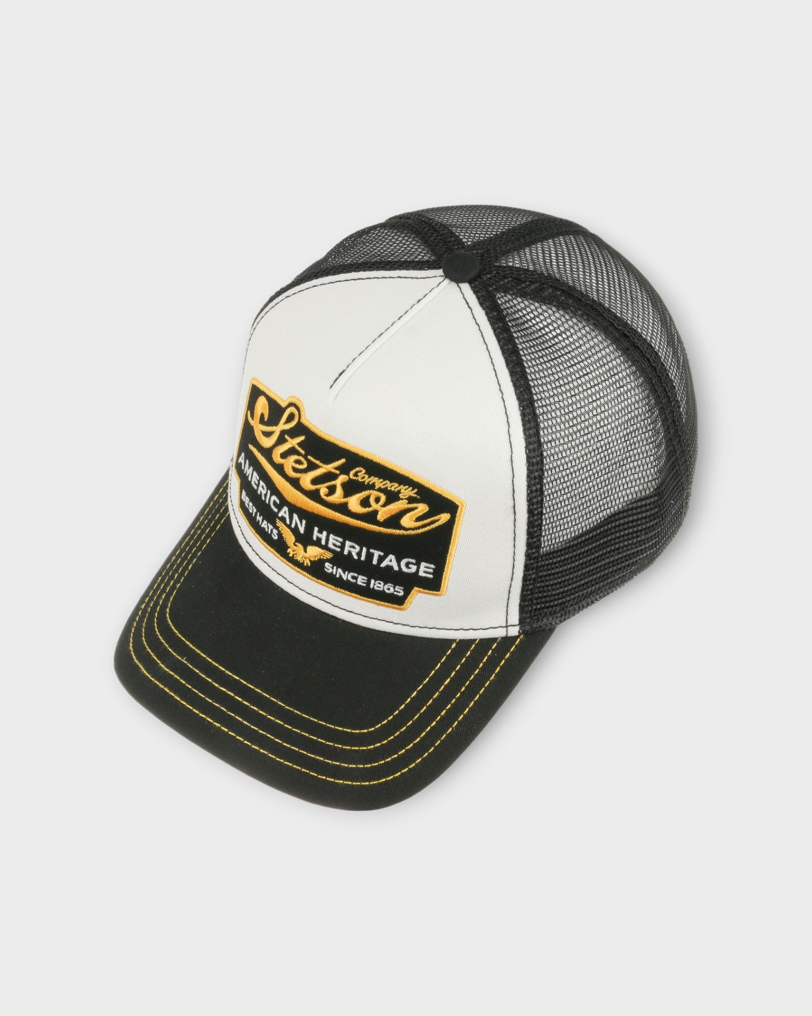 Trucker Cap American Heritage Black fra Stetson Hats. Sort kastet til med med hvid og gul. Her set fra siden.