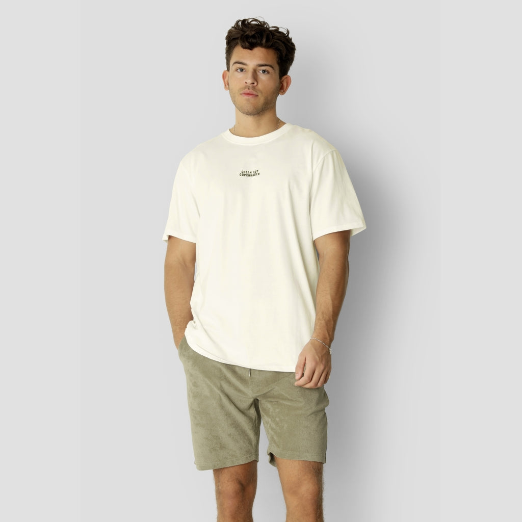 Clean Cut Copenhagen Cohen Brushed Tee SS i Ecru – en blød og komfortabel t-shirt med børstet finish, klassisk pasform og tidløst design. Perfekt til både afslappede og stilrene outfits.