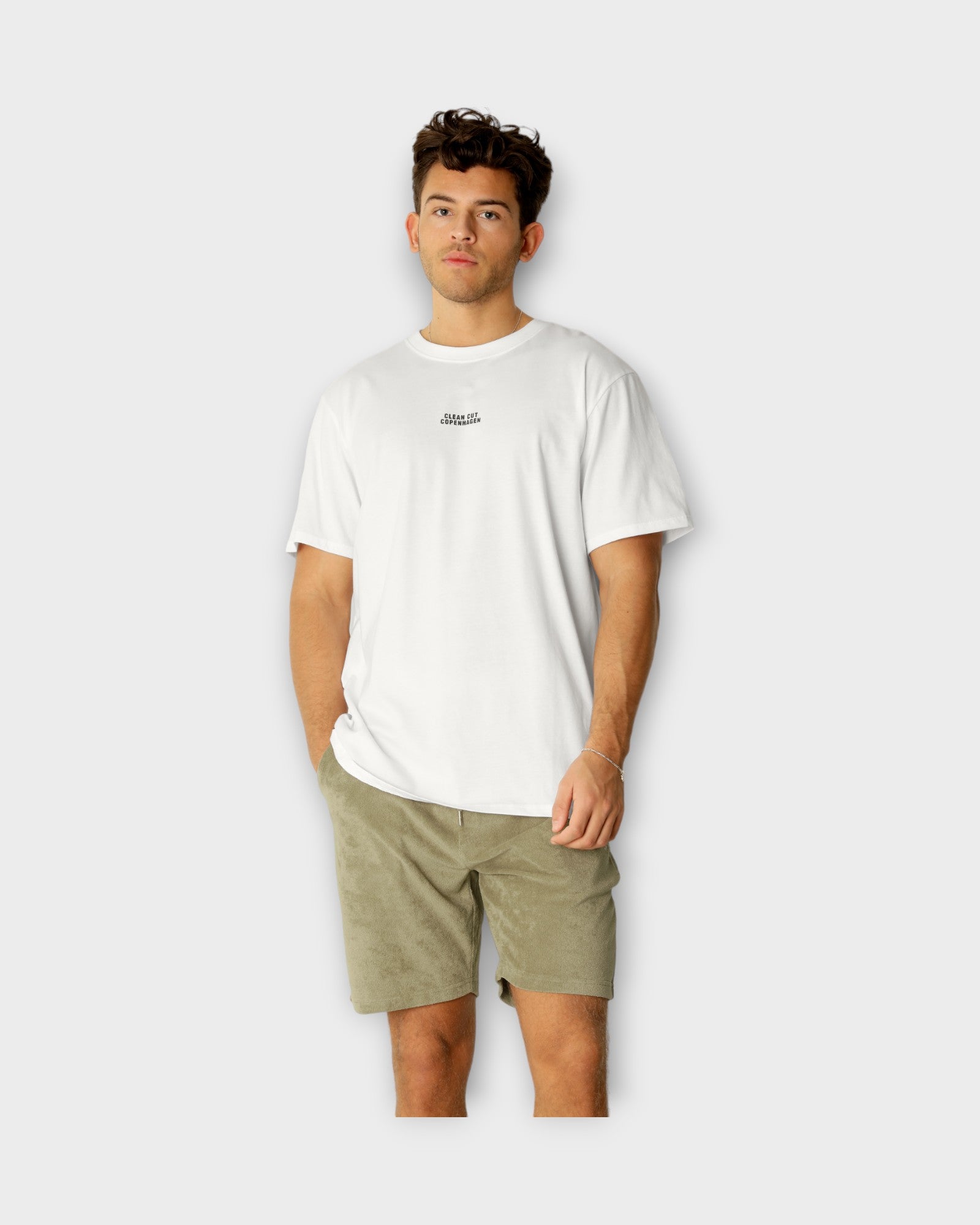 Cohen Organic Tee White fra Clean Cut Copenhagen. Hvid T-shirt til mænd med logo. Her set på model i closeup.