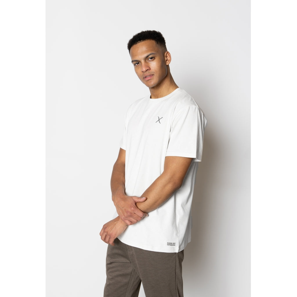 Clean Cut Copenhagen Cross Logo Organic Tee i White – en klassisk hvid t-shirt i 100% økologisk bomuld med diskret logo på brystet. Blød, åndbar og perfekt til både casual og stilrene outfits.