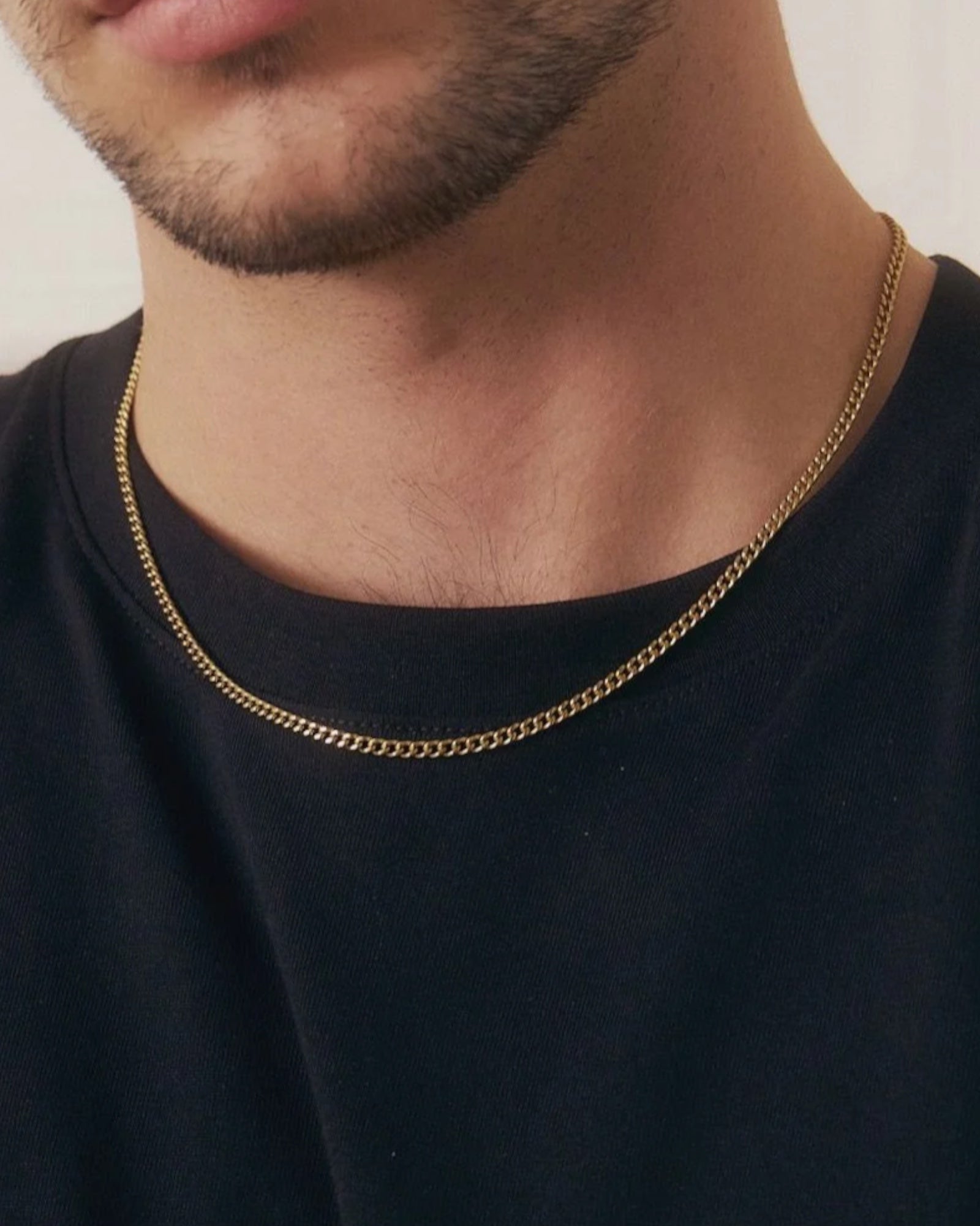 Gold men's Sam necklace by Edblad featuring a sleek chain and minimalist design, shown close-up against a plain background.