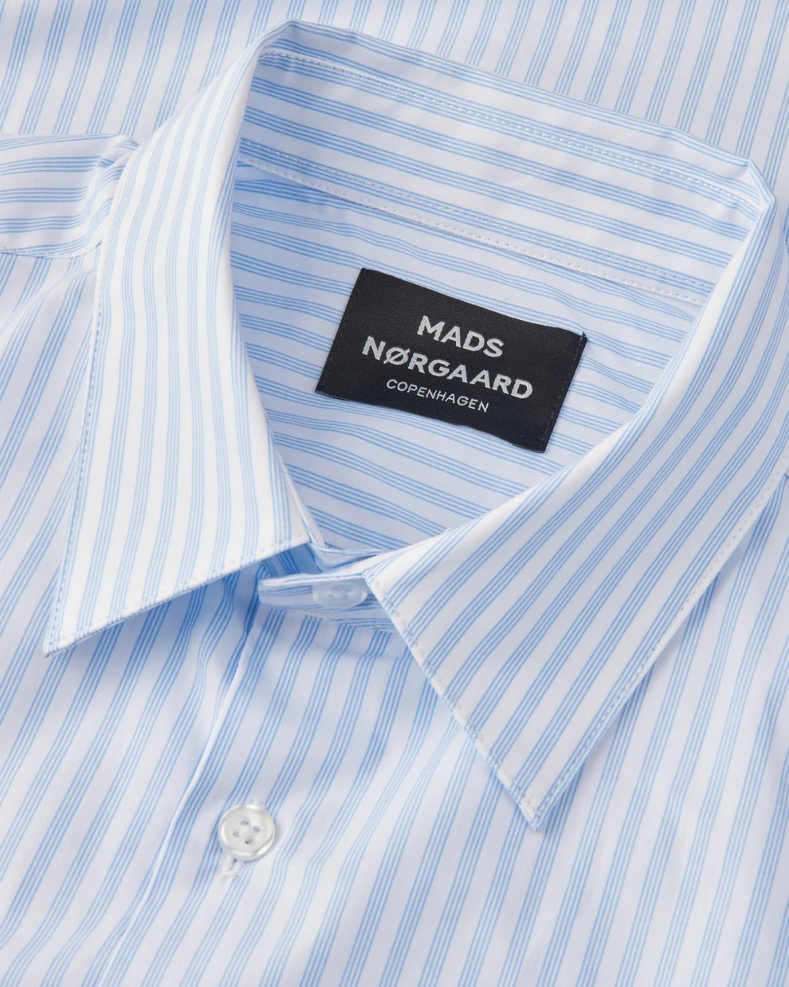 Mads Nørgaard Organic Cotton Poplin Sune Shirt i White/Blue 4 Stripe – en klassisk skjorte med elegante blå striber og et moderne design, perfekt til både formelle og afslappede looks.