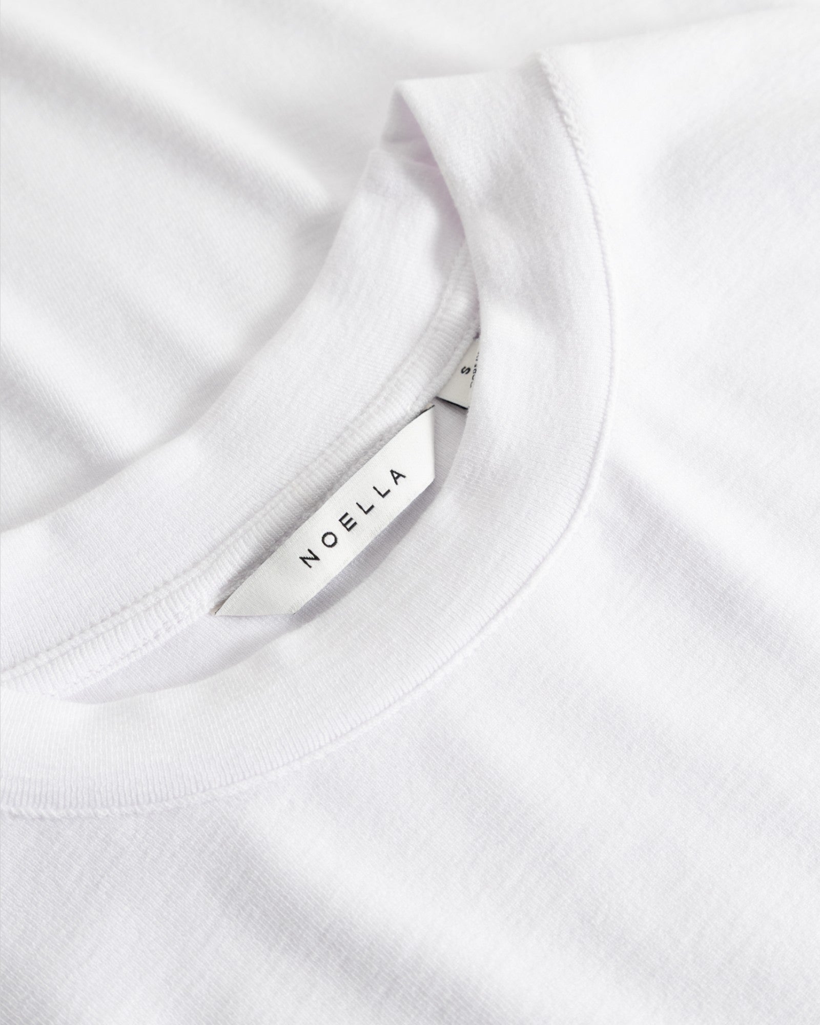 Hvid Noella Lidie SS Top, let strikdesign, kortærmet top i blødt materiale, vist på model.