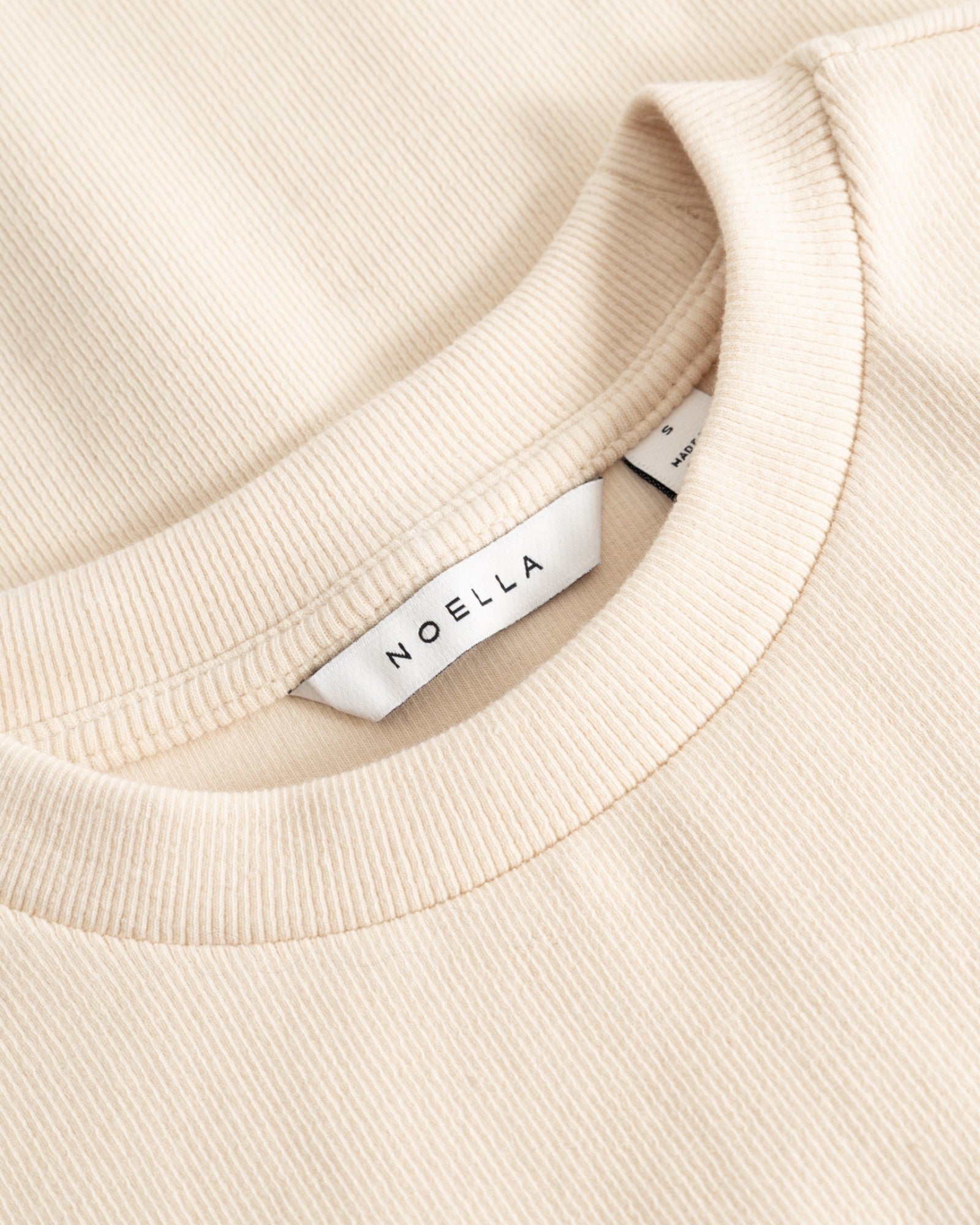Noella N-Lidie SS Top i ivory med kort ærme og rund hals, vist på model, lavet af let stof.