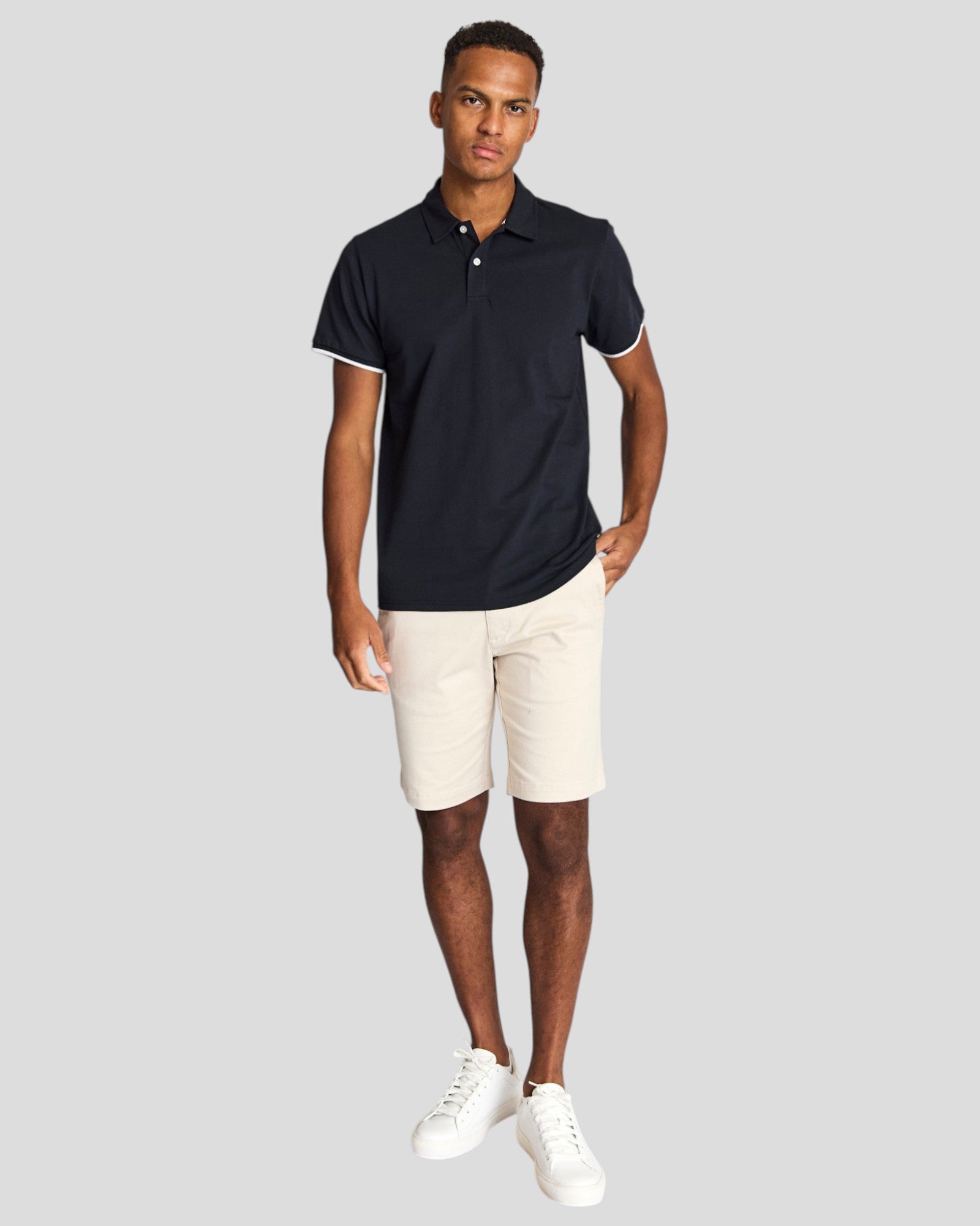Navy Bruun & Stengade Delos regular fit polo shirt displayed on a mannequin, showcasing the classic collar and short sleeves.
