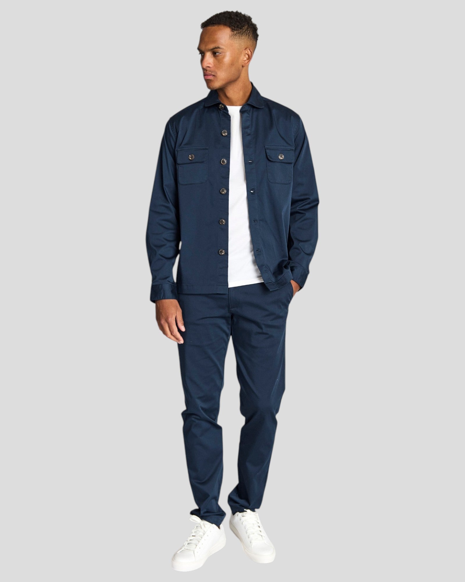 Navy Bruun & Stengade Rocco regular fit overshirt displayed on a hanger, showcasing casual style and button-up design.