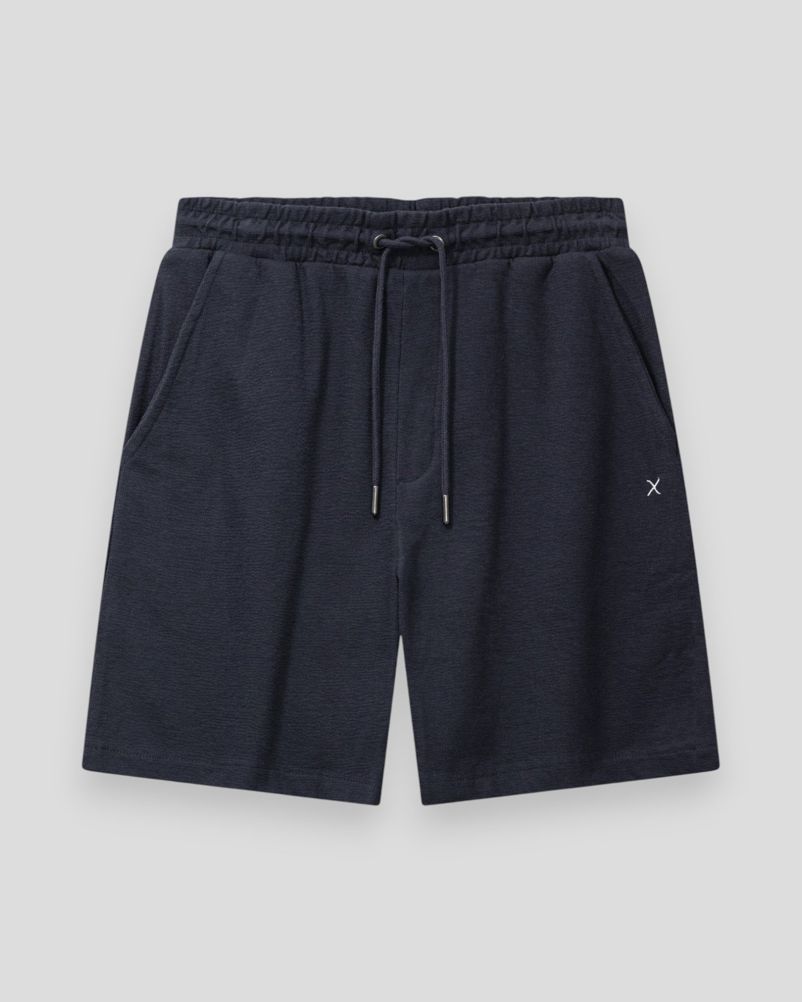 Mørk navy Calton strukturerede shorts fra Clean Cut Copenhagen vist på et hanger, fremhæver det moderne design og kvalitet.
