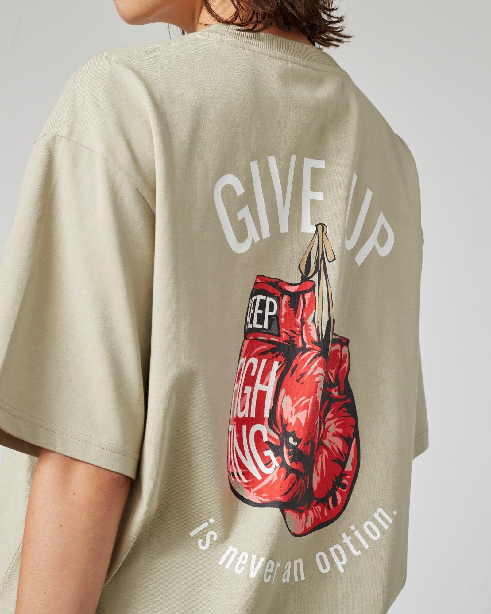 Lysegrå Everlast T-shirt med "Never Give Up" print, blødt bomuldsstof og afslappet pasform, synlig i billedet.