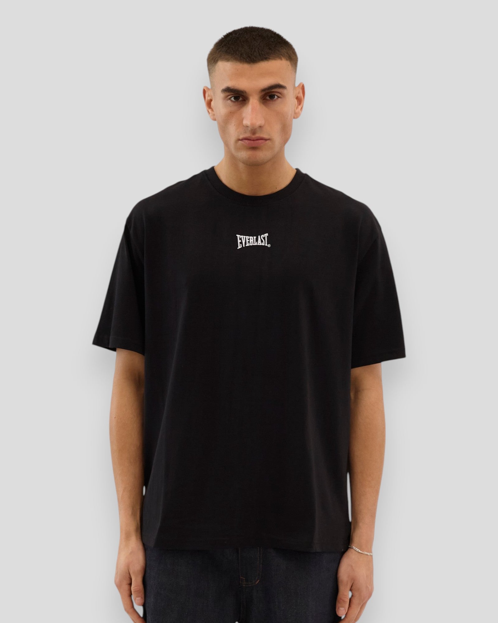 Sort Everlast Never Give Up Tee med sort design, blødt bomuldsstof og afslappet pasform, vises på modellen.