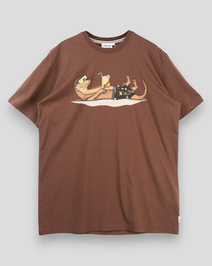 Lakor Otter Vacation Tee i Chicory Coffee farve, afslappet t-shirt med otter-illustration, vises i nærbillede.