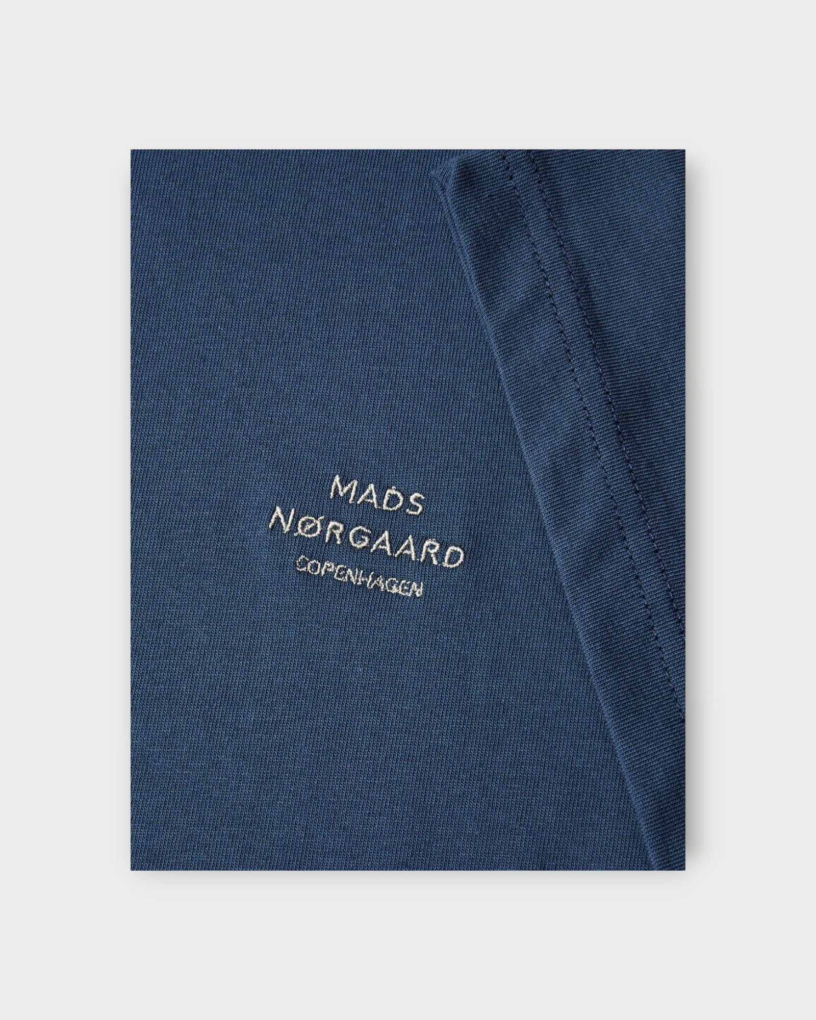 Frode Emb Logo Tee Midnight Navy - Blå Mads Nørgaard T-shirt til mænd. Her ses et closeup af logoet.