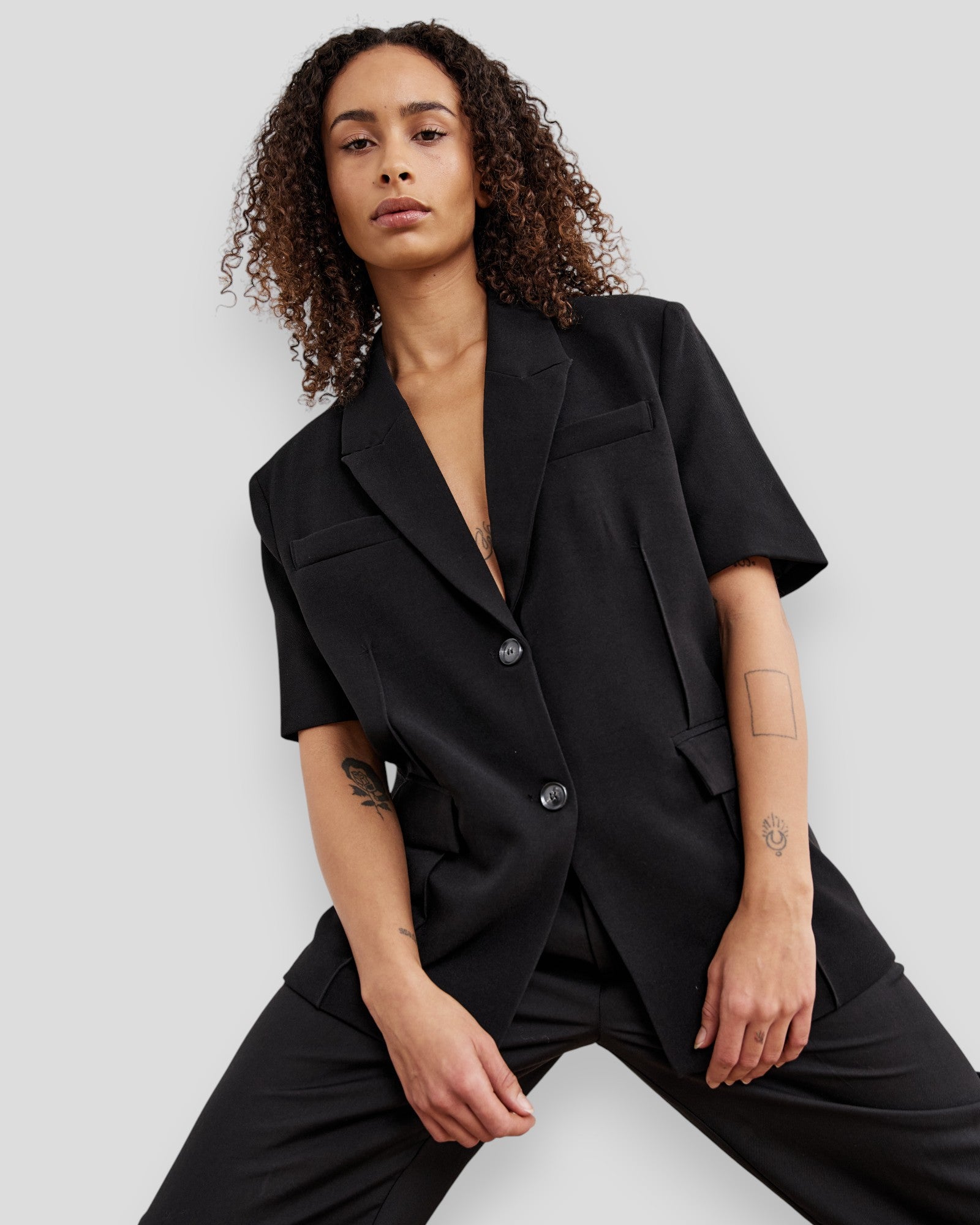 Black women's N-Leanne Crop Blazer by Noella displayed on a hanger, showcasing its tailored fit and sleek design.