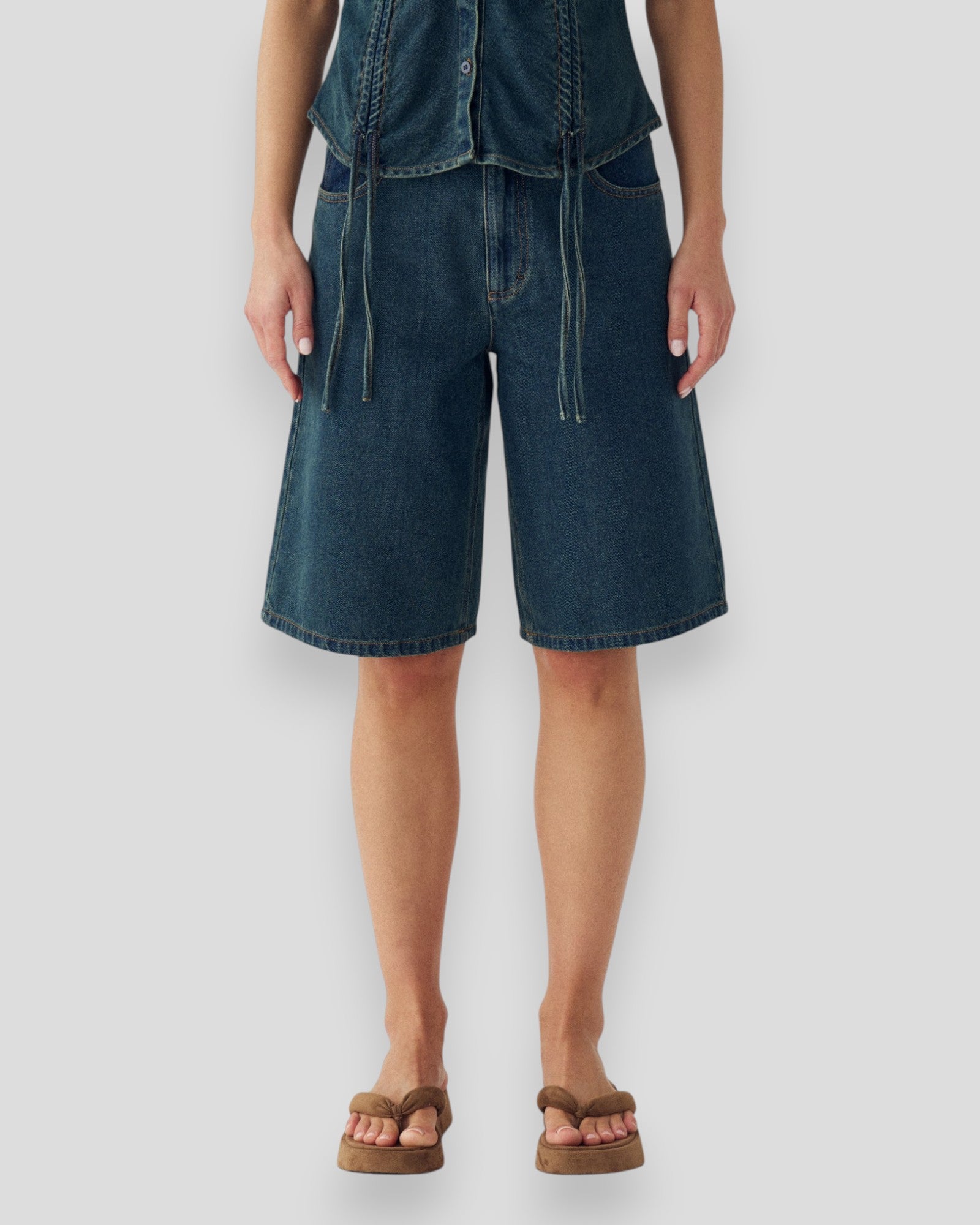 Kvinde i Noella N-Katy MW Jorts i vintage blå vask, moderne denim shorts med afslappet pasform og slidte detaljer.