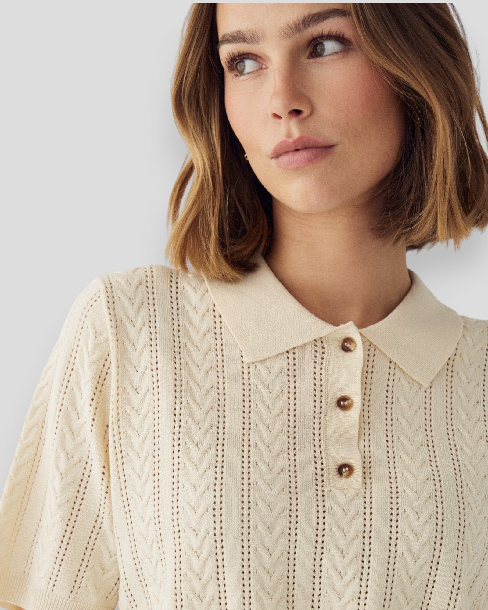 Kvinde i hvid Noella N-Mecca Knit Polo, afslappet og stilfuldt med ribdetaljer og polo-krave, set forfra.