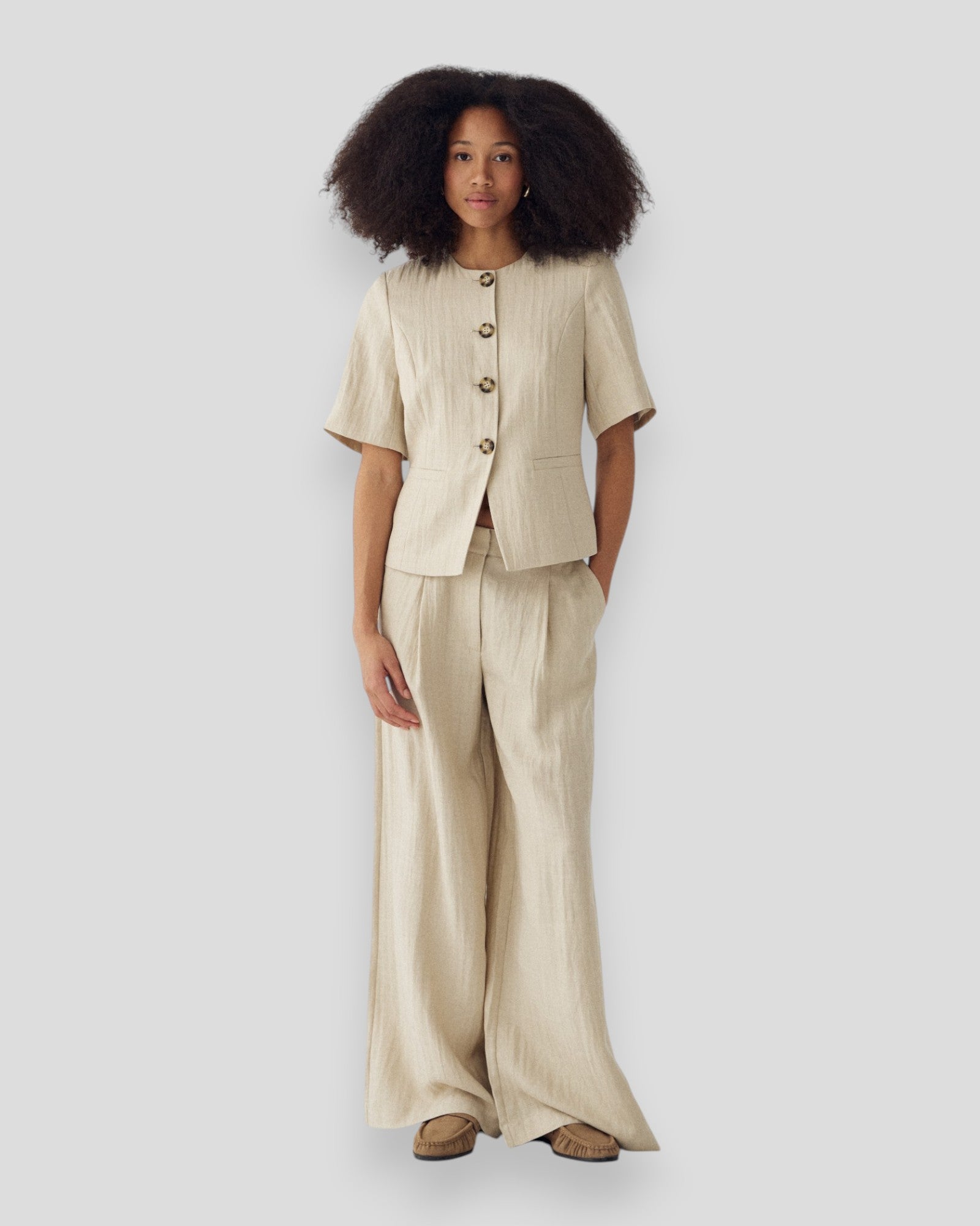Kvinde bærer en Noella N-Kasaundra blazer i oyster, stilfuld dames blazer med elegant snit og let tekstur.