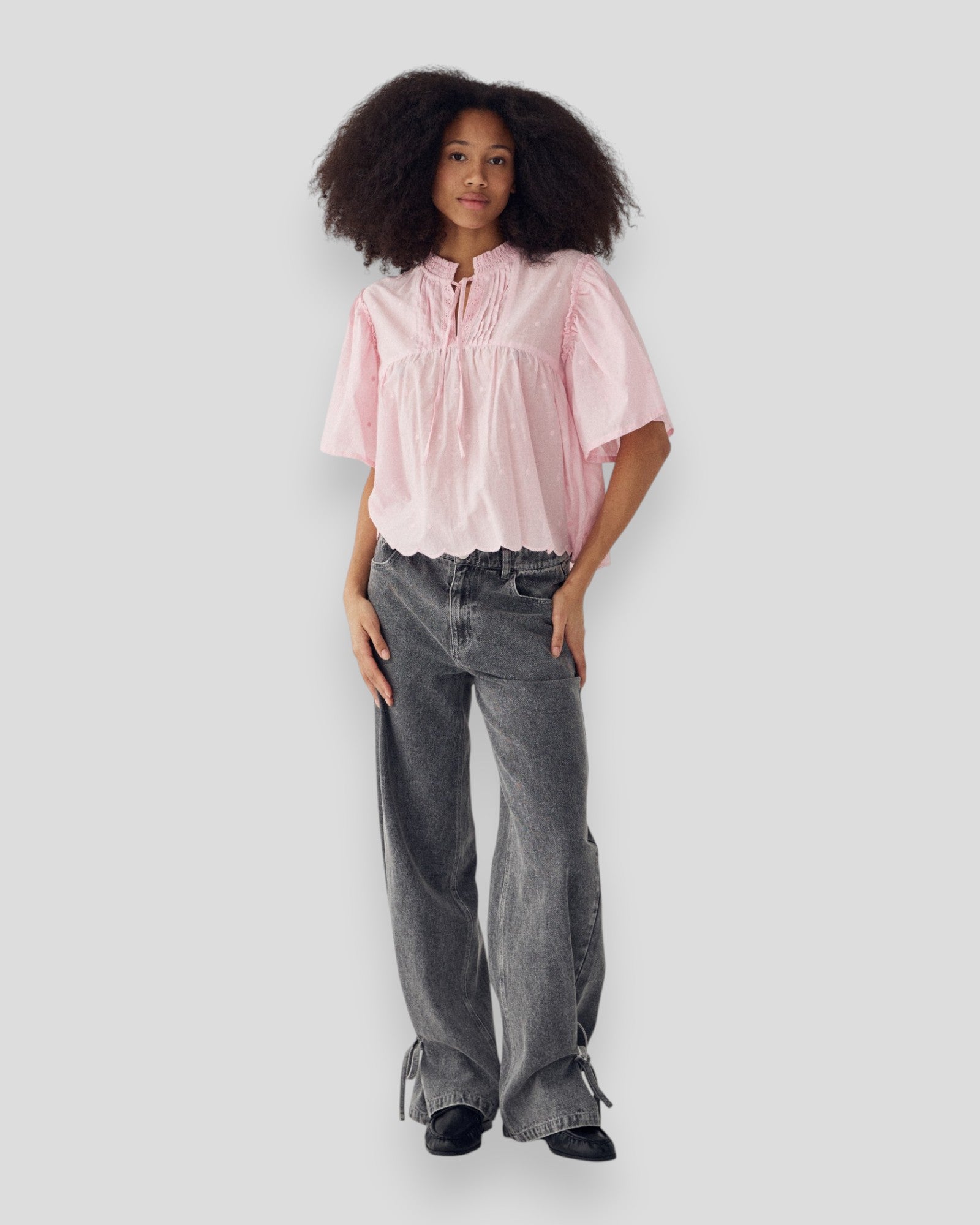 Kvinde i Noella N-Marielle bluse i blush pink, vises i et afslappet, elegant design med let stof og lange ærmer.