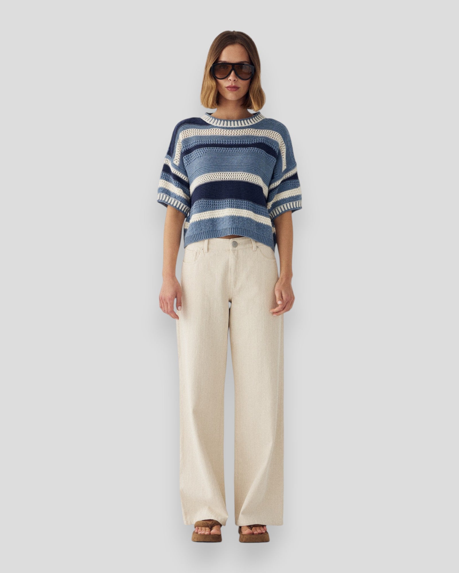 Kvinde i hvide N-Melo MW jeans fra Noella, afslappet stil, synlige lommer og pasform, baggrund med neutral setting