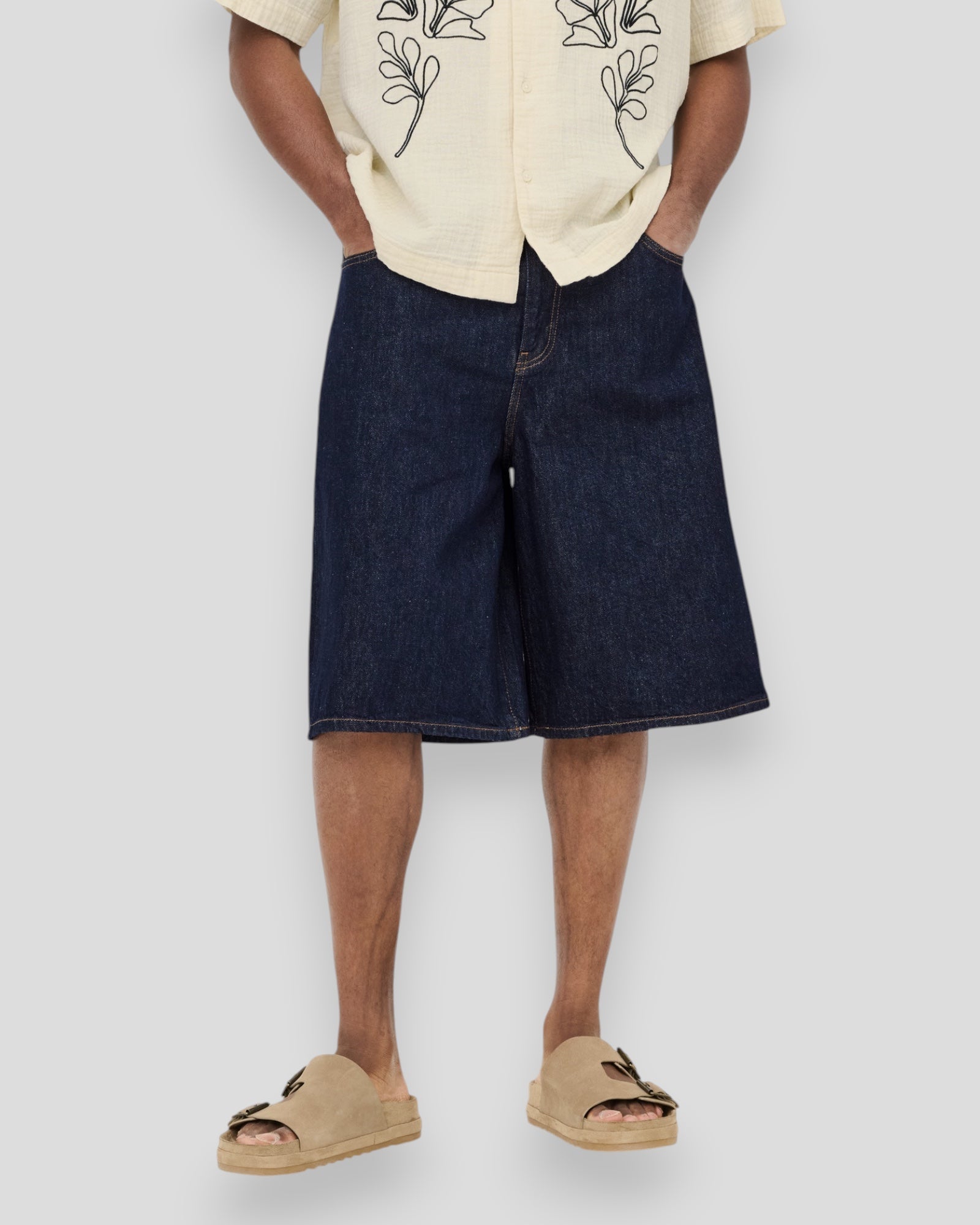 Dark blue denim jorts from ONLY & SONS, Carl Rinse 6916, featuring a classic fit and distressed details, styled for casual wear.