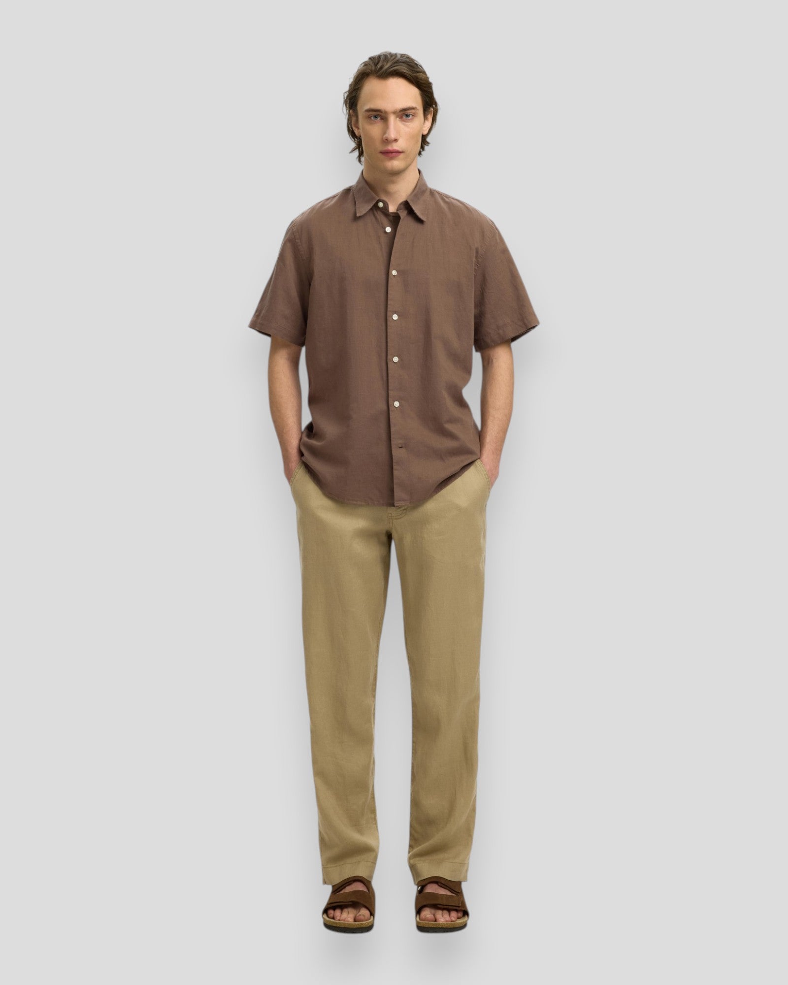 Mandlige model iført Regular Claus Clay Linen Blend SS Shirt i chokoladebrunt fra Selected, vises på billedet.