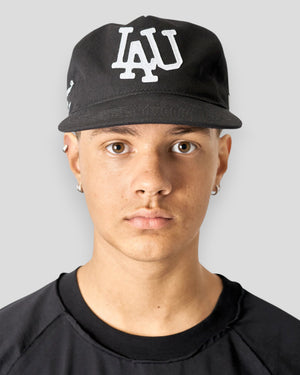Sort baseballkasket fra Lau Lau med frontdetaljer, vist fra forsiden. Komfortabel og stilfuld cap til daglig brug.