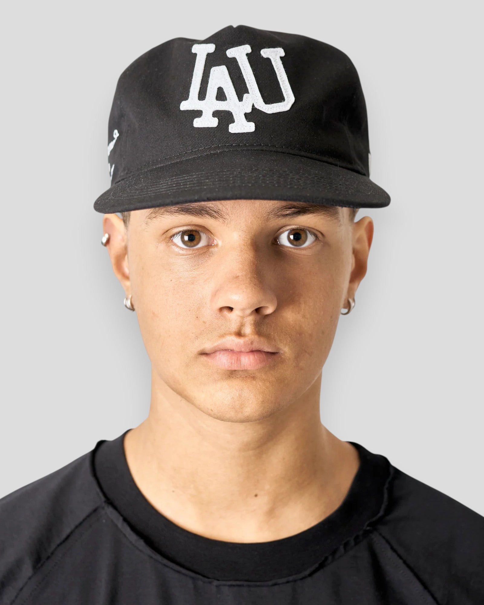 Sort baseballkasket fra Lau Lau med frontdetaljer, vist fra forsiden. Komfortabel og stilfuld cap til daglig brug.