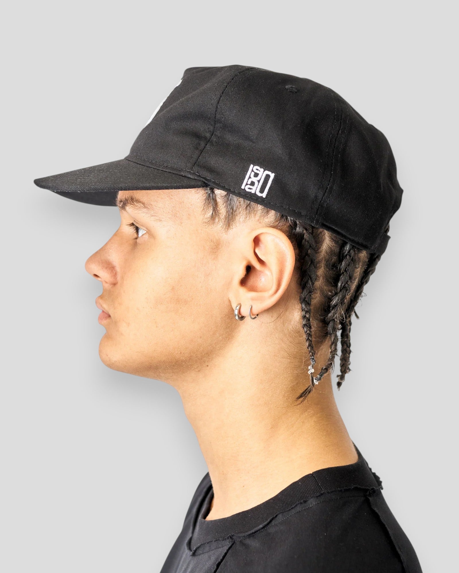 Sort Lau Lau baseball cap set fra siden, visende den sorte cap med justerbart bånd og logo på forsiden.