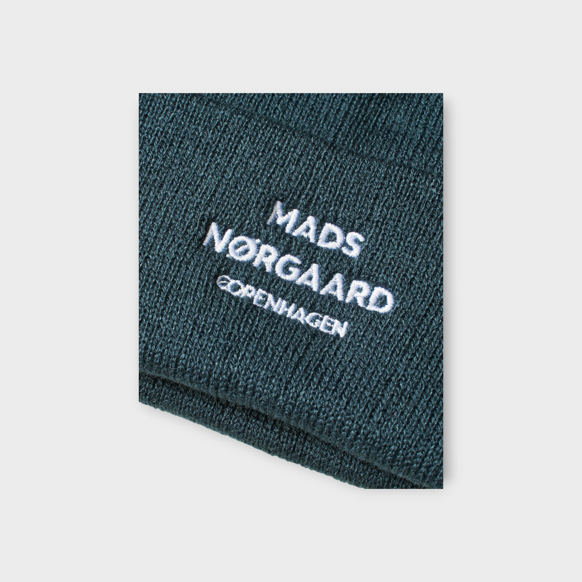 Blå Mads Nørgaard Hue til Mænd - Isak Logo Ambas Beanie Midnight Navy. Her set i closeup.