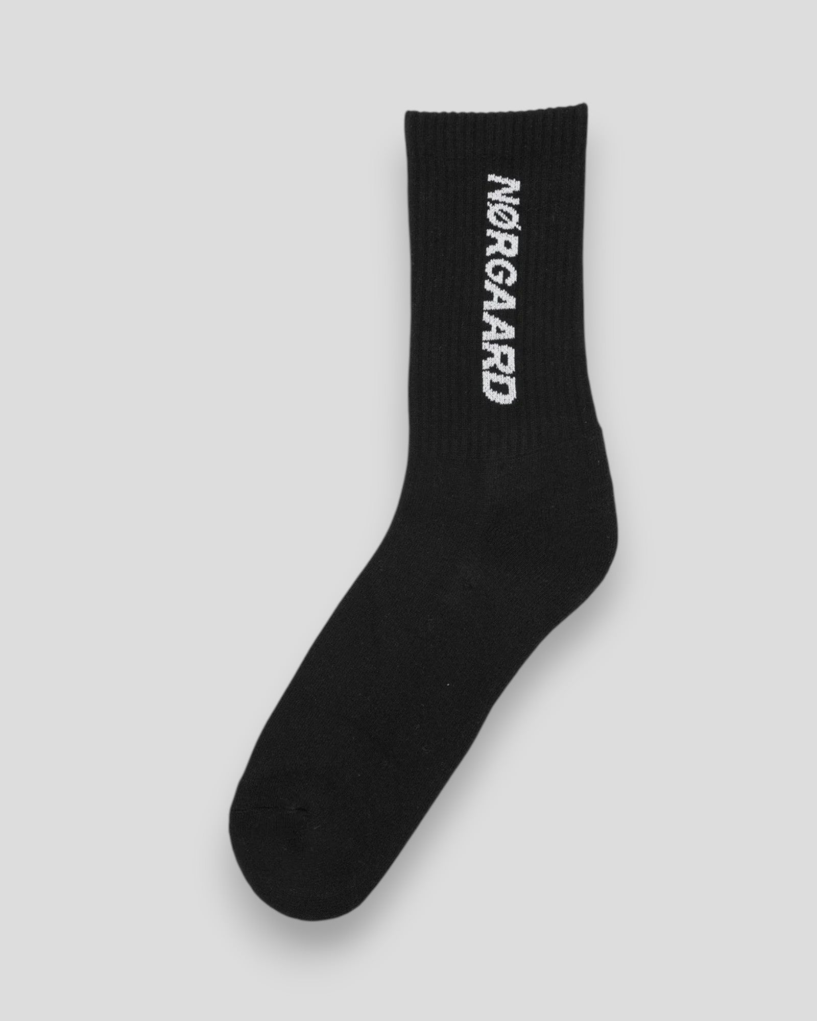 Mads Nørgaard Classic Tennis Sock i Black – en klassisk sort strømpe med tidløst design, perfekt til både sport og hverdagsbrug.